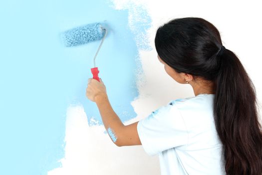 roller in woman hand paint on the wall