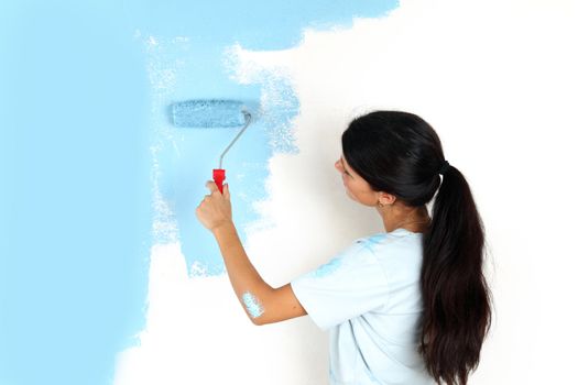 roller in woman hand paint on the wall