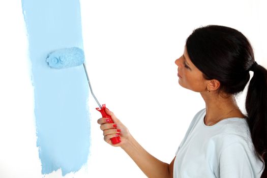 roller in woman hand paint on the wall