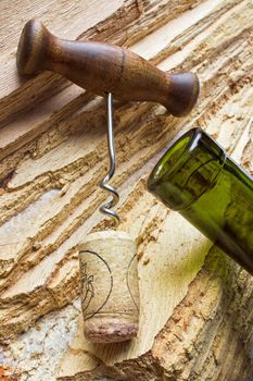 corkscrew with a cork from a bottle on the background texture of the wood