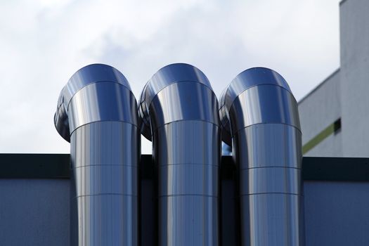 Pipes of ventilation are located on a wall of a residential building