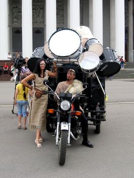 Amazing drummer sits at the bike with a lot of various drum, VDNH, Moscow, Russia