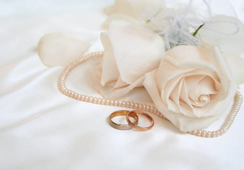Wedding rings and roses as background