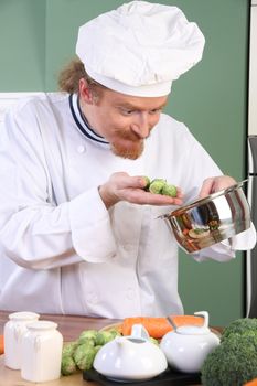 Funny young Chef with Brussels sprouts, preparing lunch in kitchen