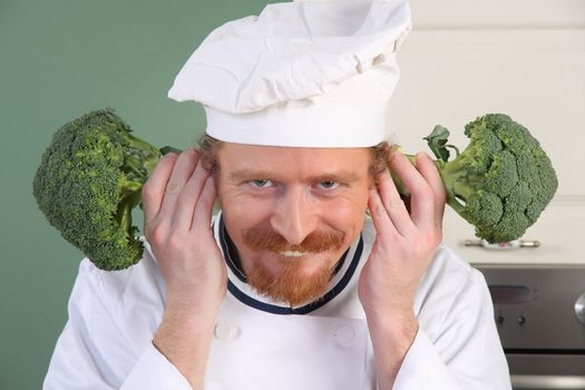 Funny young Chef with broccoli, preparing lunch in kitchen