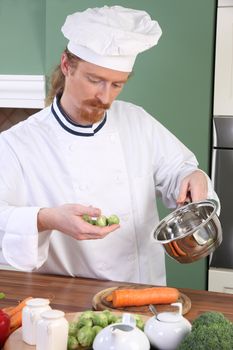 Young Chef with Brussels sprouts, preparing lunch in kitchen