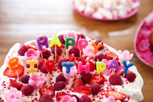 Close up of a delicious cake with candy letters on top that spell happy birthday