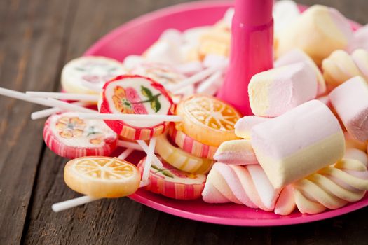 Lollypops and marshmallows on a pink plate are delicous birthday candy