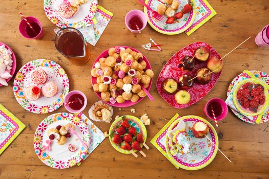 Bitrhday table stacked with all kind of colorful and delicious treats