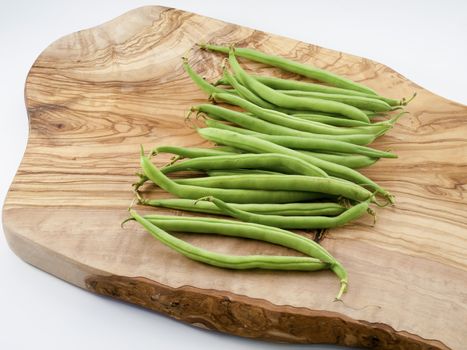 long green beans on a wooden board