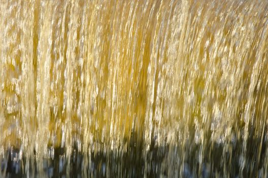 Flow down dam water closeup beautiful sunlit backdrop background.