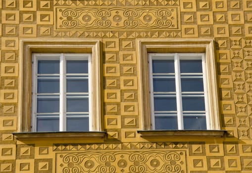 Ancient building architectural decorative windows ornamented yellow wall.