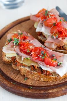 Italian bruschetta dressed with olive spread, grilled cheese, ham, roasted tomatoes and green cress,