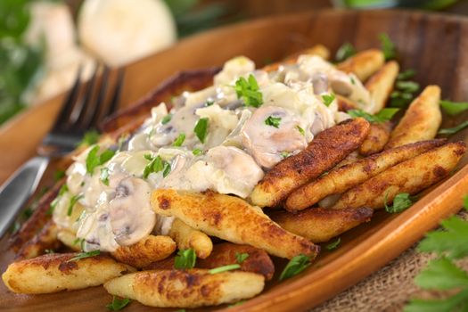 Schupfnudeln (Swabian potato noodles from Southern Germany) with mushroom sauce (Selective Focus, Focus on the front of the mushroom sauce) 