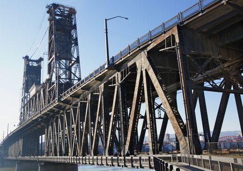 Old rusty steel bridge that carries rail and road traffic in Portland OR