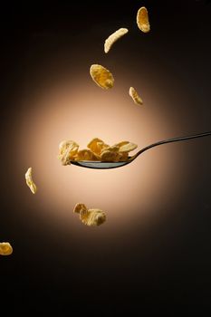 tasty corn flakes are falling down on spoon