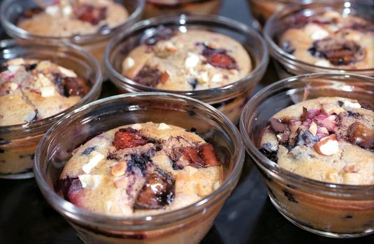 Tasty muffins with berries and nuts on the cookie sheet