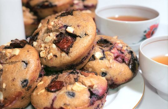 Muffins cakes with berries and nuts on the plate