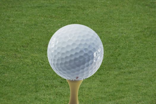 A golf ball on a tee ready to be hit