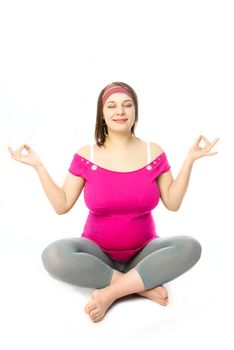 beautiful young pregnant woman in lotus pose isolated against white background