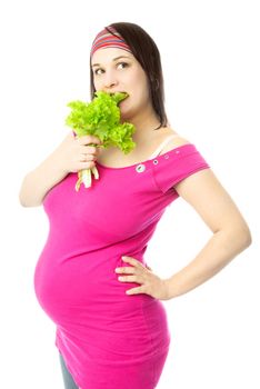 portrait of a young pregnant woman eating green salad against white background