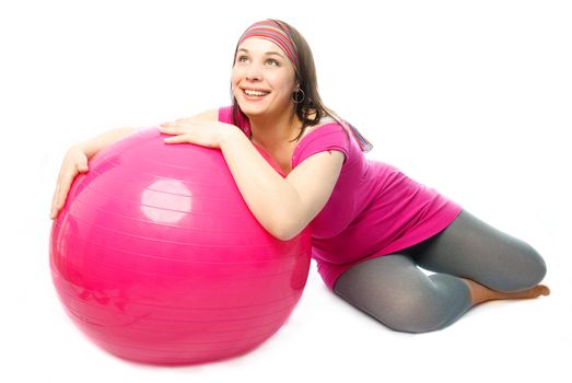 happy beautiful pregnant woman making some exercises on a fitness ball