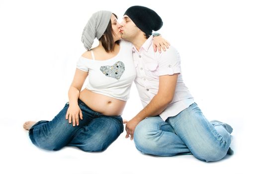 happy family, young beautiful pregnant woman and her husband embracing and kissing