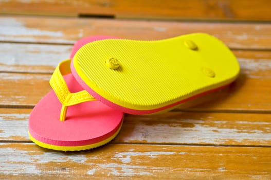 pink and yellow slipper on wood