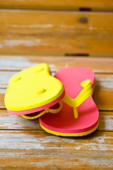 pink and yellow slipper on wood