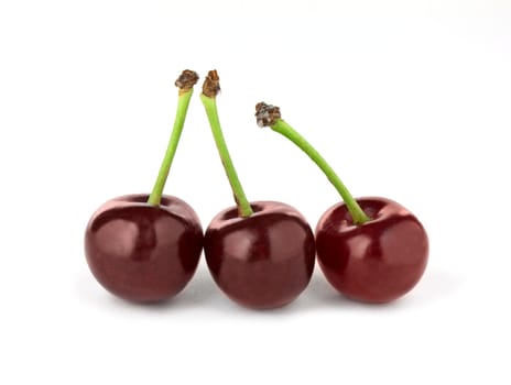 Three red cherries isolated on white background