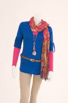 Mannequin dressed in colorful cloth, blue sweater, beige pants and