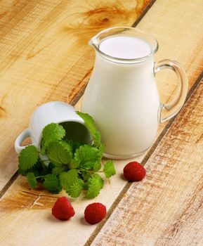 Healthy Breakfast with Jug of Milk, Raspberries and Mint Leafs on Wooden background