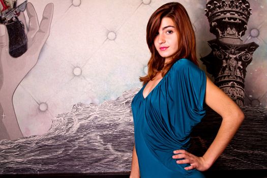 View of a beautiful young girl on a blue dress inside a bar pub.