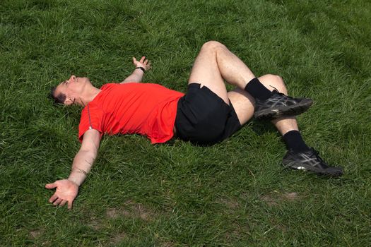 Middle Age Man exercising and stretching on grass in the sunshine