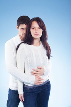 Portrait of a romantic young couple standing together in studio