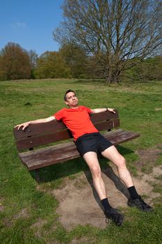 Tired Middle Age Man Exercising Resting on Sunny Park Bench