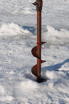 Ice Auger drilling into the ice during an ice fishing outing