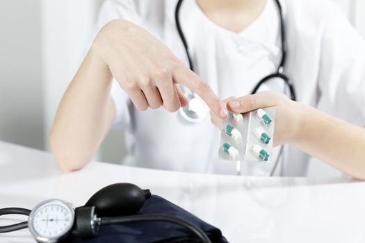 woman doctor showing pills to the patient
