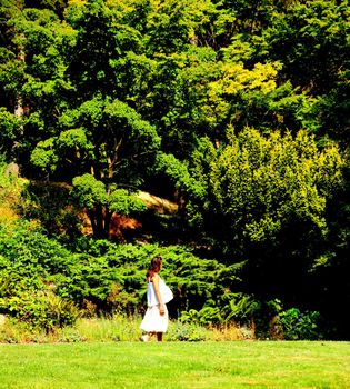 Pregnant woman walking in a public park.