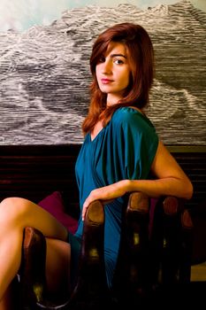 View of a beautiful young girl on a blue dress inside a bar pub.