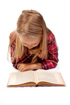 Photo of a young girl on the floor with a book