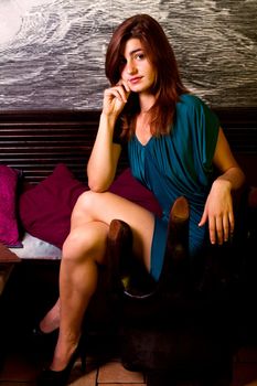View of a beautiful young girl on a blue dress inside a bar pub.