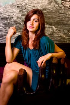 View of a beautiful young girl on a blue dress inside a bar pub.