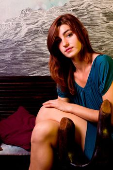 View of a beautiful young girl on a blue dress inside a bar pub.