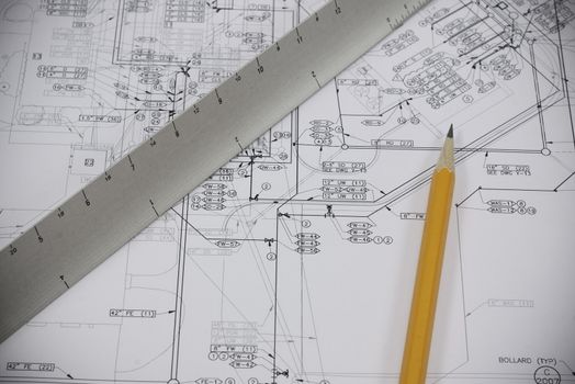 a pencil and scale on set of plans for construction