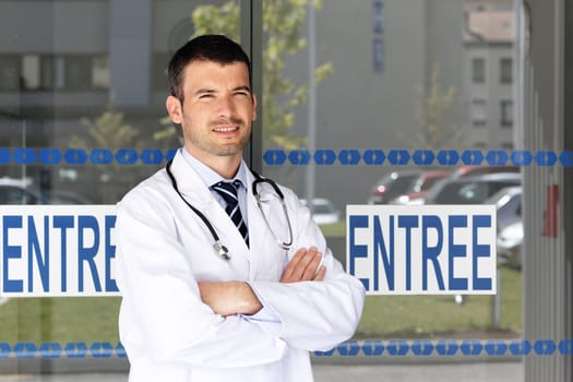 handsome doctor in front of hospital entry