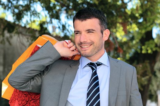 handsome businessman with bags outdoor before christmas