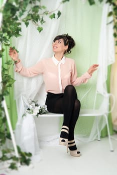 A woman in a pink blouse sitting on a bench in the green.