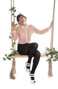 Emotional woman on a swing in the studio isolated background