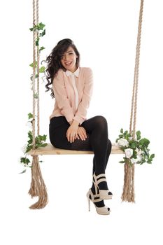 Emotional woman on a swing in the studio isolated background